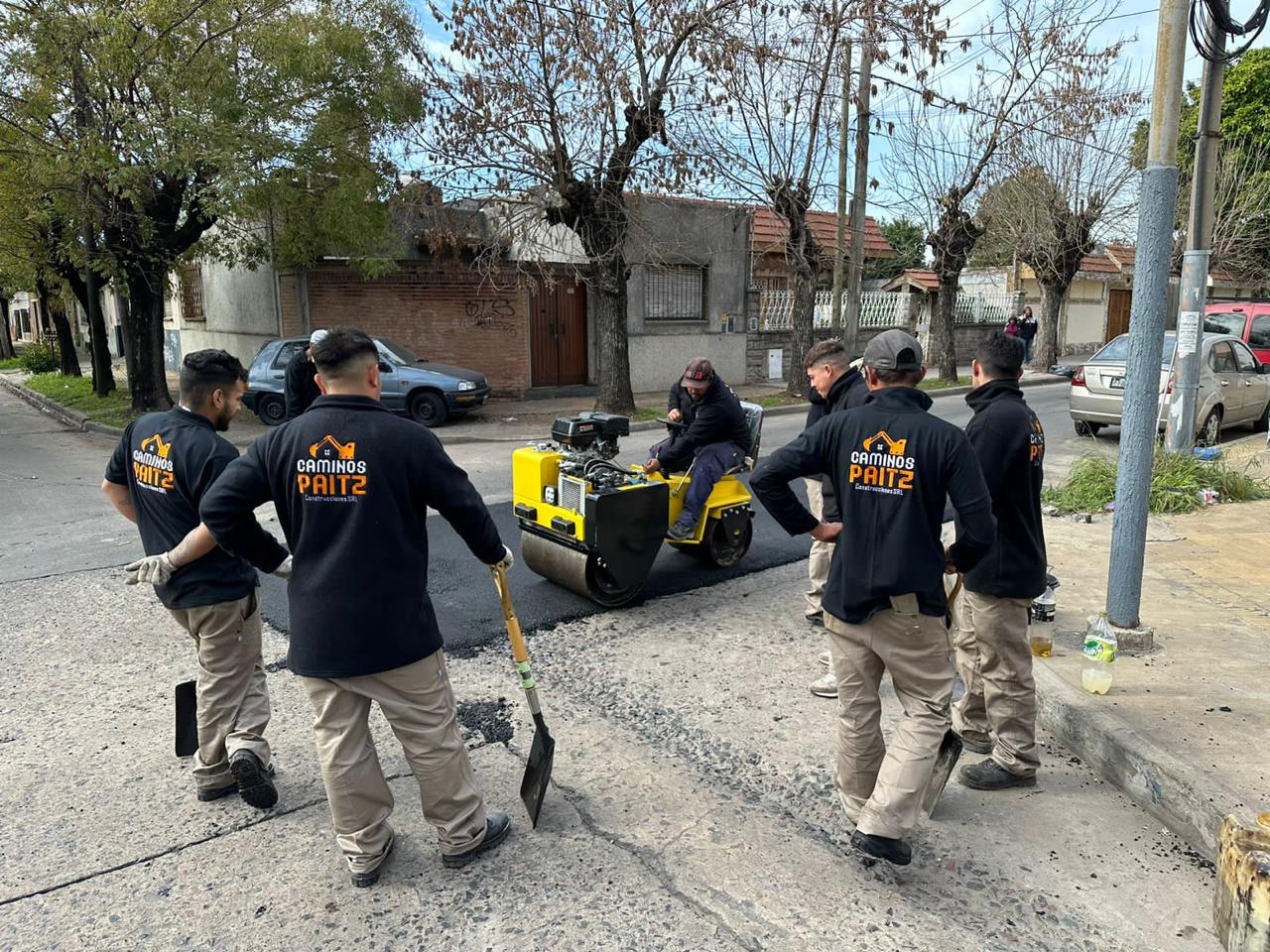 Cuadrilla de operarios sellando juntas en calle residencial de Buenos Aires