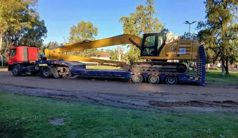 Excavadora CAT transportada sobre trailer con camión para traslado de maquinaria